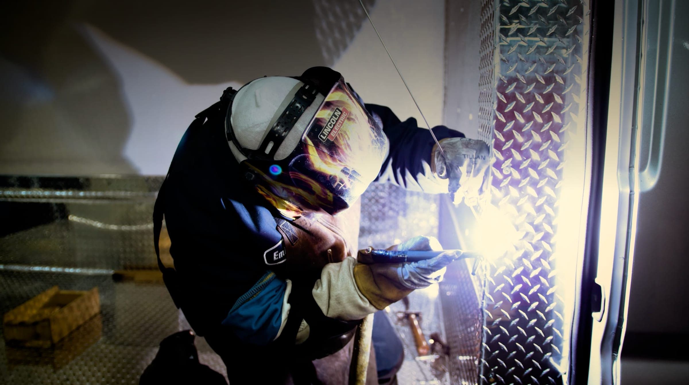 Thermo King certified technician welding diamond plate inside a van conversion